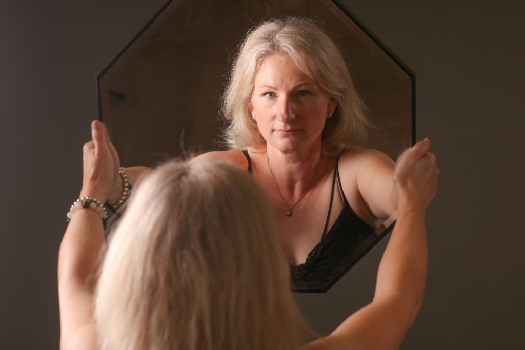 femme à la ménopause devant son miroir